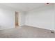 Inviting bedroom with neutral carpet, pristine white walls, and an entrance into another room at 19110 E 96Th Pl, Commerce City, CO 80022