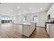 Open-concept kitchen with a large island, white cabinets, and stainless steel appliances at 19110 E 96Th Pl, Commerce City, CO 80022