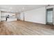 Open concept living room featuring wood-style floors, white walls, and a kitchen with a breakfast bar at 19110 E 96Th Pl, Commerce City, CO 80022