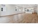 Bright living room with white walls, wood-style floors, and an open layout leading to a modern kitchen at 19110 E 96Th Pl, Commerce City, CO 80022