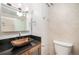A bathroom with a dark granite countertop, wood grain cabinets, and tile floors at 1020 15Th St # 18I, Denver, CO 80202