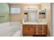 This bathroom includes a tub, vanity, and an extra large mirror with good lighting at 11565 Decatur St # 7D, Denver, CO 80234
