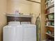 A practical laundry area equipped with a washer, dryer, and shelving for organized storage solutions at 11565 Decatur St # 7D, Denver, CO 80234