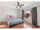 Comfortable bedroom with a large window, a ceiling fan, hardwood floors, and neutral decor at 15627 E 51St Dr, Denver, CO 80239