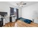 Well-lit bedroom with a ceiling fan, window, and desk area at 15627 E 51St Dr, Denver, CO 80239