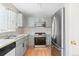Functional kitchen featuring modern appliances, laminate countertops, light blue cabinetry, and hardwood flooring at 15627 E 51St Dr, Denver, CO 80239