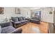 Cozy living room with hardwood flooring, comfortable sofas and chairs, and natural light from a large window at 15627 E 51St Dr, Denver, CO 80239