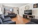 Comfortable living room with hardwood floors, plush sofas and chairs, a tv, and neutral decor at 15627 E 51St Dr, Denver, CO 80239