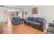 Bright living room featuring hardwood floors, two sofas, an armchair, and decorative wall art at 15627 E 51St Dr, Denver, CO 80239