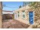 Brick-paved backyard with neutral brick house, blue trim, windows, doors, and wooden fence at 2222 N Williams St, Denver, CO 80205