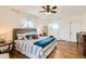Bedroom with hardwood floors, ceiling fan, large window, and a nicely decorated bed at 2222 N Williams St, Denver, CO 80205