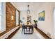 Bright dining room features exposed brick wall, hardwood floors, and modern light fixture at 2222 N Williams St, Denver, CO 80205