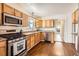Kitchen with stainless steel appliances, light wood cabinetry, granite countertops, and hardwood floors at 2222 N Williams St, Denver, CO 80205