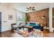 Bright living room with exposed brick wall, hardwood flooring, and modern decor at 2222 N Williams St, Denver, CO 80205