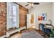 Office with exposed brick, hardwood floors, large window, area rug and work space at 2222 N Williams St, Denver, CO 80205