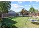 Expansive backyard featuring lush lawn, playset, shed, and swing set, perfect for outdoor enjoyment at 7629 Depew St, Arvada, CO 80003