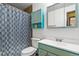 Clean bathroom is complemented by turquoise cabinets and coordinating shower curtain at 7629 Depew St, Arvada, CO 80003