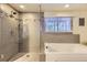 Bathroom with large soaking tub, glass shower, and modern tile work throughout at 540 Ithaca Dr, Boulder, CO 80305