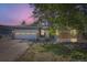 Charming single-story home featuring a brick facade, two car garage, and xeriscaped front yard at twilight at 540 Ithaca Dr, Boulder, CO 80305