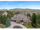 Stunning aerial view of a home with a circular driveway, mature trees, and beautiful landscaping at 4 White Fir Ct, Littleton, CO 80127