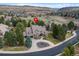 Beautiful aerial view of a house with a circular driveway, mature trees, and lush landscaping at 4 White Fir Ct, Littleton, CO 80127