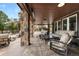 Spacious covered back patio with comfortable seating and a stone fireplace at 4 White Fir Ct, Littleton, CO 80127