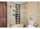 Bathroom with glass door shower, tiled walls and floors, and storage shelves at 4 White Fir Ct, Littleton, CO 80127