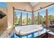 Elegant bathroom with a soaking tub surrounded by windows, granite countertops, and scenic outdoor views at 4 White Fir Ct, Littleton, CO 80127