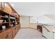 Bonus room with built-in wooden cabinets and a large carpeted area, perfect for entertaining or relaxing at 4 White Fir Ct, Littleton, CO 80127