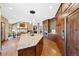 Open kitchen and living room layout with granite countertops, wooden cabinets, and a stone fireplace at 4 White Fir Ct, Littleton, CO 80127