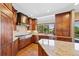 Kitchen featuring wooden cabinets, stainless steel appliances, and a large window offering natural light and green views at 4 White Fir Ct, Littleton, CO 80127