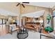Open-concept living room with hardwood floors, high ceilings, a fireplace, and seamless access to the kitchen at 4 White Fir Ct, Littleton, CO 80127