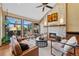 Comfortable living room featuring a stone fireplace, high ceilings, a ceiling fan, and lots of natural light at 4 White Fir Ct, Littleton, CO 80127