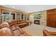 Spacious living room with a stone fireplace, large windows, and a brown leather couch at 4 White Fir Ct, Littleton, CO 80127