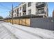 Modern condo building with secure gated access and snow covered driveway at 336 E 1St Ave # 200, Denver, CO 80203