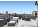 Large snow covered rooftop deck features city views with dining and lounge furniture at 336 E 1St Ave # 200, Denver, CO 80203