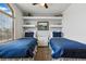 Charming bedroom with two twin beds, blue bedding, and white furniture at 8427 Pierson Ct, Arvada, CO 80005