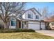 Charming two-story home featuring a brick facade, white siding, and a three-car garage at 8427 Pierson Ct, Arvada, CO 80005