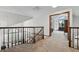 Upstairs hallway leading to primary bedroom suite features plush carpeting and views of the staircase and living room at 8427 Pierson Ct, Arvada, CO 80005