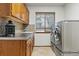 Well-equipped laundry room with washer, dryer, ample counter space, and stone accents at 8427 Pierson Ct, Arvada, CO 80005