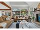 Bright living room featuring large windows, a brick fireplace, and comfortable sofas at 8427 Pierson Ct, Arvada, CO 80005