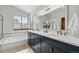 Bright main bathroom featuring double sinks, marble countertops, modern fixtures and a relaxing tub at 8427 Pierson Ct, Arvada, CO 80005