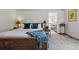 Comfortable main bedroom boasts natural light, a wicker bed frame, and a glimpse into the ensuite bath at 8427 Pierson Ct, Arvada, CO 80005