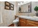 Charming powder room with custom wall paper, wood floors, tiled countertop, framed mirror, and unique decorative touches at 8427 Pierson Ct, Arvada, CO 80005