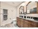Bathroom featuring double vanity with dark countertop and wood cabinets, providing ample storage at 2061 S Worchester Way, Aurora, CO 80014
