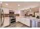 Updated kitchen features white cabinets, stainless appliances, and an open layout to the adjacent living room at 2061 S Worchester Way, Aurora, CO 80014