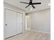 Bright bedroom features modern ceiling fan, neutral walls, light, wood-look flooring and sliding closet doors at 1475 S Eaton St, Lakewood, CO 80232