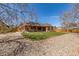 Beautiful backyard with a covered patio, lush lawn, and mature trees, perfect for outdoor living at 5448 S Swadley Ct, Littleton, CO 80127