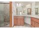 Bathroom featuring a granite countertop vanity, a shower, and framed mirrors at 5448 S Swadley Ct, Littleton, CO 80127