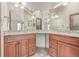 Bathroom featuring a granite countertop vanity with dual sinks and framed mirrors at 5448 S Swadley Ct, Littleton, CO 80127